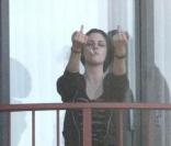 De retour à son hôtel après une balade sur un bateau, Kristen Stewart fume une cigarette sur le balcon de sa chambre... et adresse un petit signe gracieux aux photographes, le dimanche 30 mai à Sydney, en Australie.