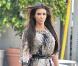 Kim Kardashian dans une belle petite robe en soie Diane Von Furstenberg rehaussée d'une large ceinture, qu'elle avait choisi de revêtir avec une paire de bottes Christian Louboutin et un sac Balenciaga.