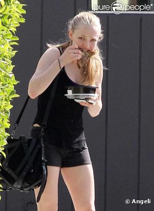 Amanda Seyfried promène son chien et dévore un sandwich, à Los Angeles, en mars 2011.