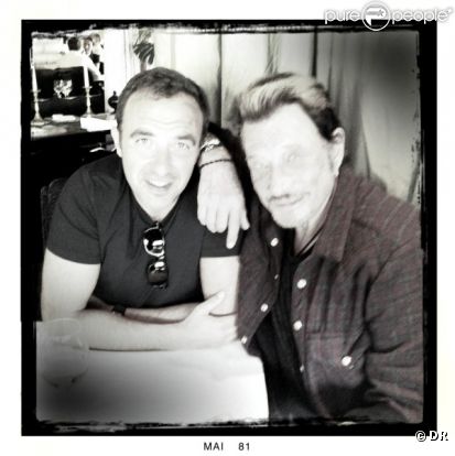 Johnny Hallyday et Nikos Aliagas posent au restaurant Le Murat, à Paris, le 10 mai 2011. 