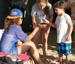 Rihanna se pose quelques minutes pour discuter avec deux enfants à la Barbade le 29 décembre 2011