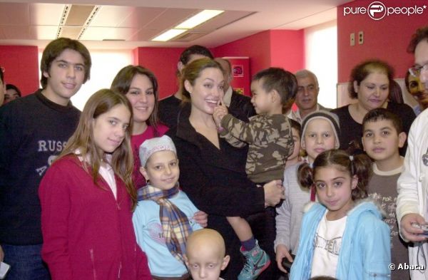 Angelina Jolie à Beyrouth au Liban dans un centre pour enfants malades du cancer, en décembre 2004. Elle pose avec son fils Maddox