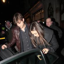 Ashton Kutcher protège sa compagne Mila Kunis à la sortie du Trendy scotts Restaurant à Londres le 14 mars 2013.