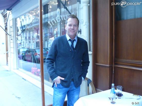 Kiefer Sutherland à la terrasse d'un restaurant parisien, seul et souriant