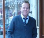 Kiefer Sutherland à la terrasse d'un restaurant parisien, seul et souriant