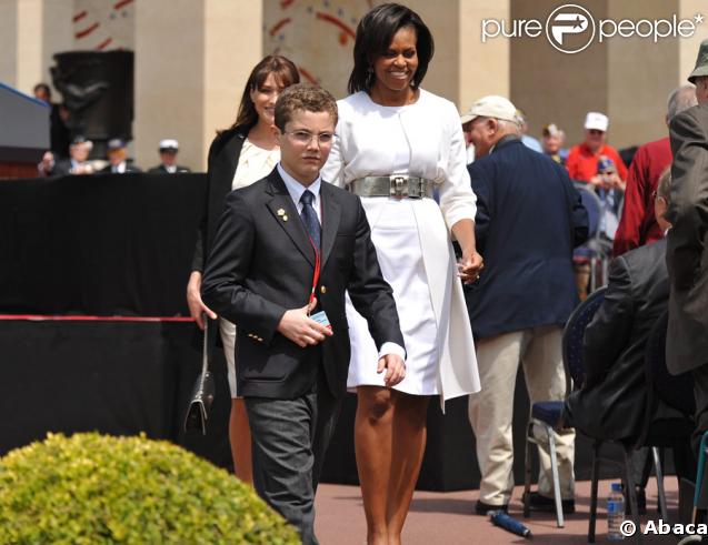 Louis Sarkozy escorte Michelle Obama lors de la cérémonie en hommage à ceux qui sont morts pour la France. Cimetière de Colleville-sur-mer, le 6 juin.