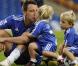 John Terry, la star de Chelsea, en pleine séance de câlins avec ses jumeaux ! Ça aussi... ça demande de l'entraînement !