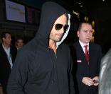 David Charvet se protège des paparazzis à son arrivée à Roissy (9 avril 2010 à Paris)