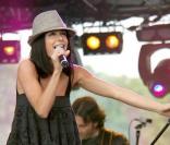 La miss twiste son look classique avec des bottes camel et un borsalino gris. Bravo pour son basique préféré : le top ample à bretelles. Concert en 2005
