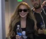 Lindsay Lohan se fait poursuivre par une meute de photographes avec un ami  dans un parking.