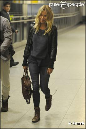 Sienna Miller adopte un look de motarde chic à Heathrow. Eh oui, elle prend l'avion mais n'oublie pas son sens du style.