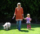 Tori Spelling, sa fille et son porc dans leur jardin à Los Angeles le 12 juillet 2011