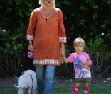Tori Spelling, sa fille et son porc dans leur jardin à Los Angeles le 12 juillet 2011