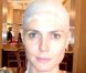 Heidi Klum débute sa transformation en plaquant ses cheveux sous un masque en silicone.
