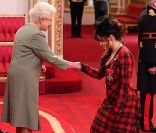 Sa majesté la reine Elizabeth II a remis les insignes de commandeur dans l'ordre de l'empire britannique à Helena Bonham Carter, vêtue d'une robe en tartan signée Vivienne Westwood, le 22 février 2012 à Buckingham Palace.