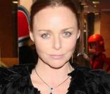 La jolie Stella prend la posedans son superbe ensemble noir, petite robe courte bouffante et gilet de pétales 
