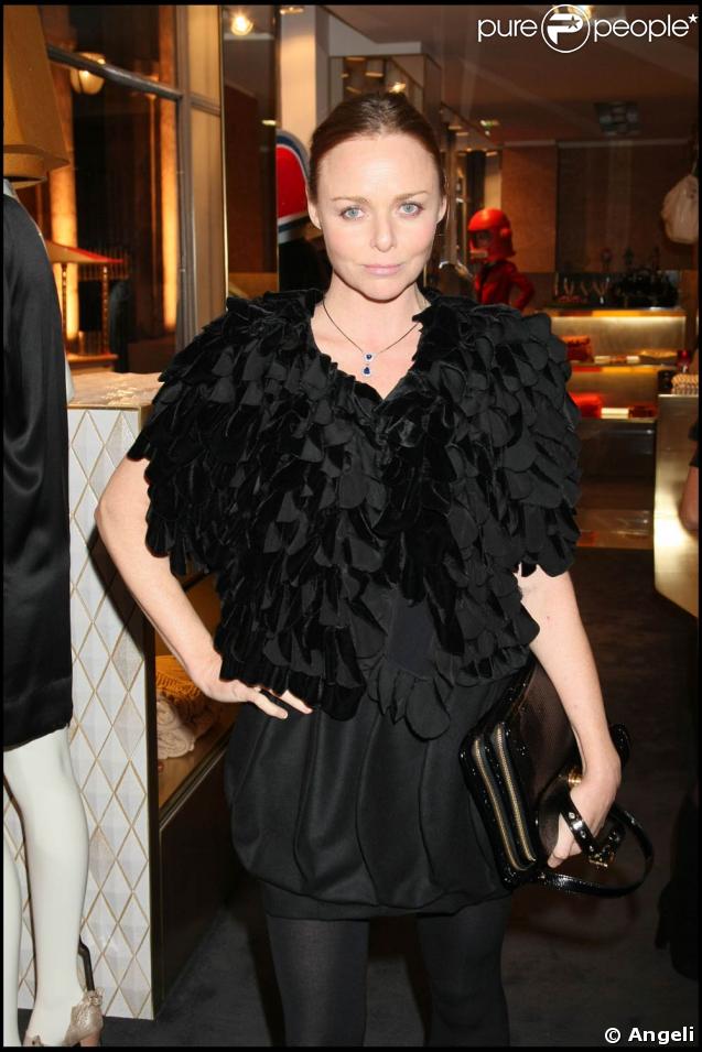 La jolie Stella prend la posedans son superbe ensemble noir, petite robe courte bouffante et gilet de pétales 