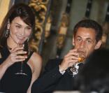 Carla Bruni ne manque pas de boire son verre en souriant, son expérience de top model s'utilise en toute circonstance 