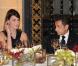 D'un geste de mannequin, Carla Bruni met son oreillette sous le regard admiratif de son époux