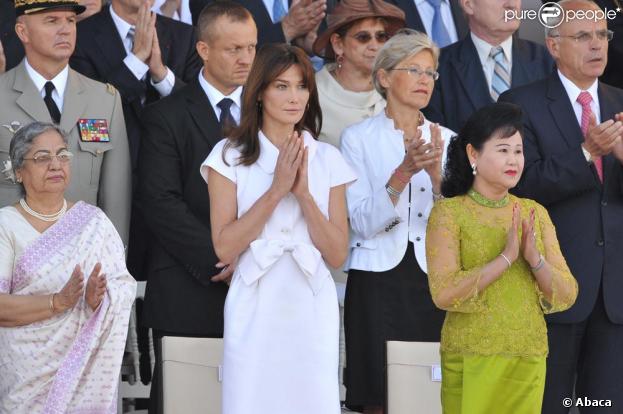 Carla Bruni lors du défilé du 14 juillet 2009 entourée de Bun Rany Hun Sen, la femme du Premier ministre Cambodgien et de Gurshara Khaur, la Première dame indienne