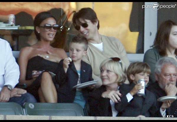 Victoria Beckham et Tom Cruise plaisantent, tandis que Cruz Beckham grignote et que Romeo Beckham boit... évidemment tout en supportant leur père David en train de jouer face au Milan AC