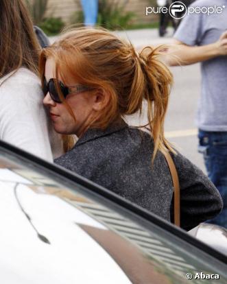 Isla Fisher se cache derrière son amie afin d'éviter les photographes à Los Angeles le 11 novembre 2009