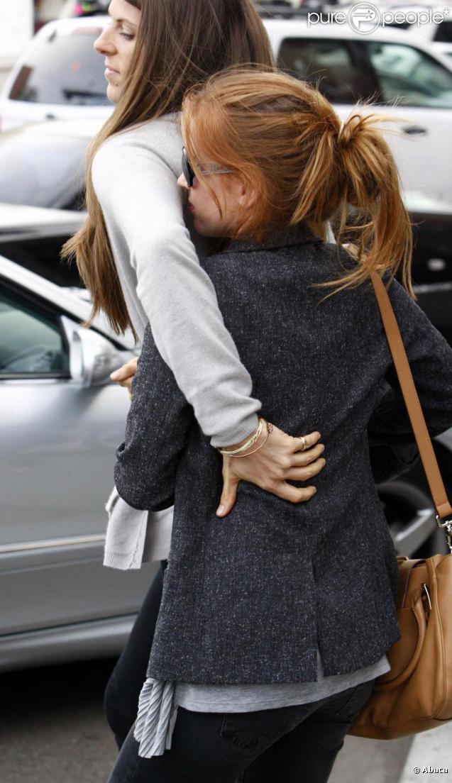 Isla Fisher se cache derrière son amie afin d'éviter les photographes à Los Angeles le 11 novembre 2009