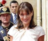 Carla Bruni, rayonnante dans sa robe mi-longue à manches courtes agrémentée d'une ceinture noire à gros grains, le tout signé Dior.
