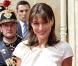 Carla Bruni, rayonnante dans sa robe mi-longue à manches courtes agrémentée d'une ceinture noire à gros grains, le tout signé Dior.