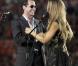 Fergie et Marc Anthony chantent l'hymne national américain, lors du match de football américain des Miami Dolphins contre l'équipe des New York Jets, le 26 septembre à Miami