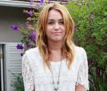 Miley Cyrus à Los Angeles, casse l'effet trop sage de sa robe en dentelle par des boots rock. Le 14 août 2011.