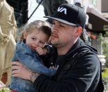 Harlow, dans les bras de son père Joel Madden, adopte une attitude rock avec ses bottes cloutées. 