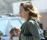 L'actrice Alicia Silverstone dans les rues de Los Angeles le 27 mars 2012, allaite son fils Bear en marchant