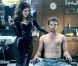 Kelly Brook, tondeuse Phillips à la main et habillée d'une robe moulante en latex, satisfait le premier client de son salon de coiffure.