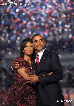 Michelle Obama, dans les bras de son cher et tendre, lors de son discours à la convention nationale démocratique en août 2008, porte une robe rouge et noire réhaussée d'une petite broche.