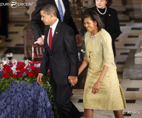 Pour réhausser, d'une petite touche classique, sa jolie robe imaginée par Isabel Toledo, Michelle Obama portait un gilet boutonné d'un bijou de broche, le 20 janvier 2009.