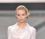 Ensemble aérien composé d'une blouse rose poudre et d'une jupe droite noire sur des escarpins à plumes, collection printemps-été 2009 signée Karl Lagerfeld pour la maison Chanel.