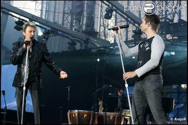 Johnny Hallyday et son fils David Hallyday sur scène face à leur public sur le Champ de Mars le 14 juillet 2009