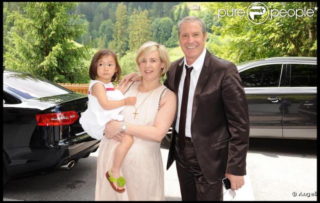 Hélène Darroze portant sa fille dans les bras et Jean-Claude Darmon lors de la journée de baptême de Joy à Gstaad en Suisse le 5 juillet 2009