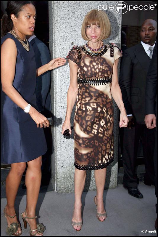 Anna Wintour dans une petite robe marron et crème aux coutures très innovantes. 