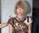 Anna Wintour dans une petite robe marron et crème aux coutures très innovantes. 