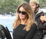 Elle Macpherson dans un petit pull noir associé à des ballerines et à un pantalon en cuir rouge totalement 