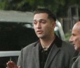 Le jour de la mort d'Amy Winehouse le 23 juillet, Reg Traviss, ex-compagnon de la star, discute avec les policiers devant son appartement où elle a été retrouvée morte, à Camden Town à Londres 