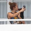 Miley Cyrus fait un bisou à son chien, depuis la terrasse de son hôtel, le jeudi 17 mai à Miami.