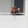 Miley Cyrus crache par dessus le balcon de la terrasse de son hôtel, le jeudi 17 mai à Miami.