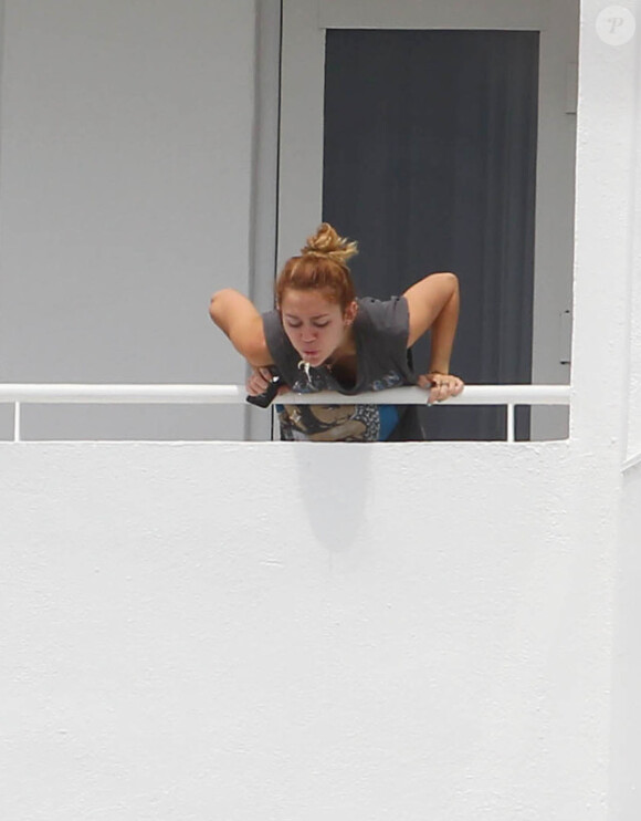 Miley Cyrus crache par dessus le balcon de la terrasse de son hôtel, le jeudi 17 mai à Miami.