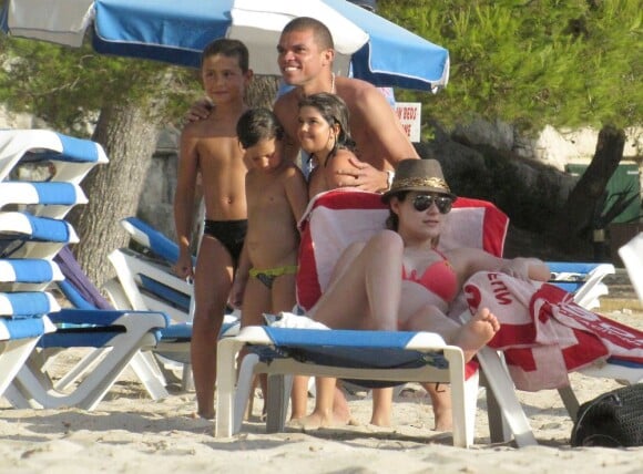Képler Laveran Lima Ferreira dit Pepe prend la pose avec de jeunes fans devant sa compagne Ana Sofia le 7 juillet 2012 sur l'île de Minorque avant la naissance de leur premier enfant prévue pour la fin de l'été