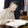 La princesse Charlene appliquée sur sa signature. Le prince Albert de Monaco et la princesse Charlene ont signé le livre d'or marquant leur venue, à la Villa Reitzenstein, à Stuttgart le 10 juillet 2012, au deuxième jour de leur visite officielle en Allemagne.