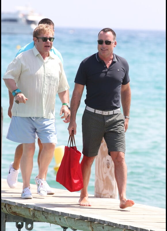 Elton John et son mari David Furnish s'offrent quelques jours à Saint-Tropez et commencent par un petit tour au Club 55 le 13 août 2012