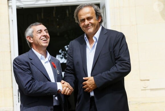 Alain Giresse reçoit la Légion d'Honneur des mains de son ancien partenaire en équipe de France Michel Platini au château du Haillan près de Bordeaux le 20 août 2012